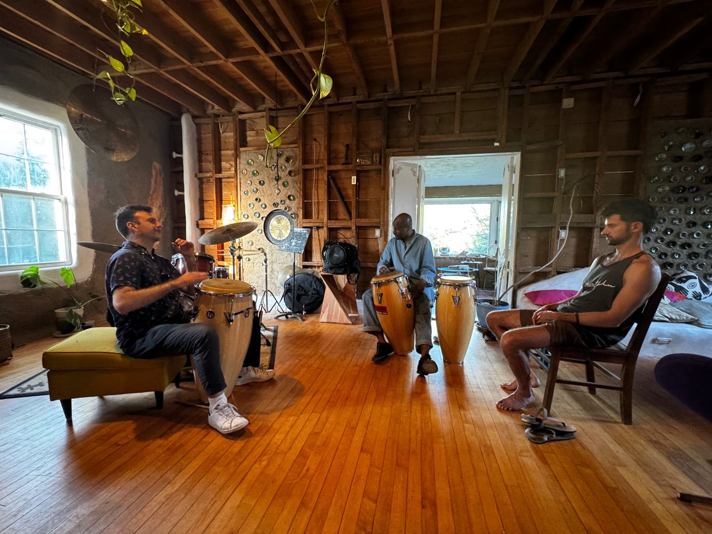Shakoor Hakeem leading a conga workshop in The Tavern's dance-hall, with bottle walls and open timber framing behind them