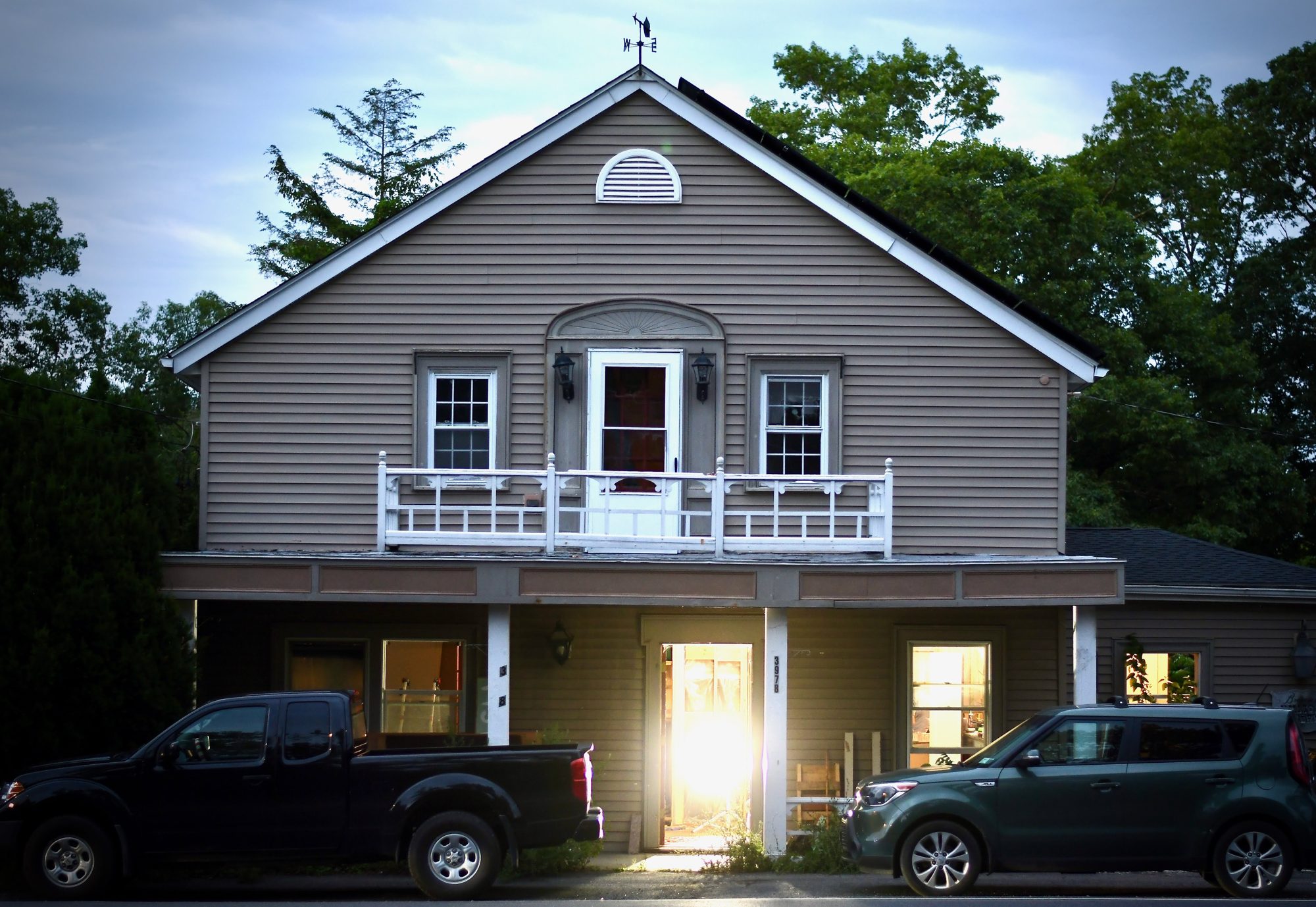 The Tavern at dusk, warm light spilling out of the open front door